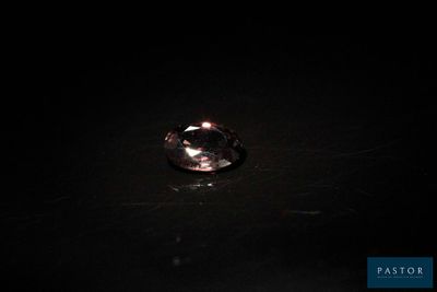 un gros plan d'une bague posée sur une table dans l'obscurité