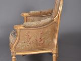 an old chair with a floral upholstered back and arms