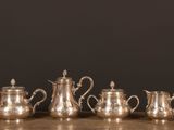 a set of five silverplated tea and coffee pots on a table