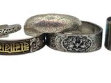 several different types of silver rings and bracelets on a white surface