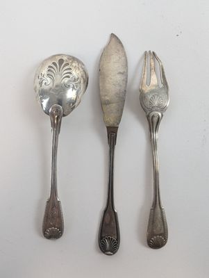 trois cuillères et une fourchette en argent sur une surface blanche