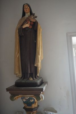 une statue représentant une femme tenant un oiseau, posée sur un socle