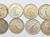 six types différents de pièces d'argent sur une surface blanche