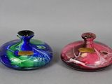 three different colored glass vases sitting next to each other on a gray surface