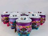 cinq jouets « Littlest Pet » sont alignés sur une surface blanche