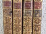 trois vieux livres posés sur une table l'un à côté de l'autre