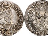 a silver coin with a crown and shield on it
