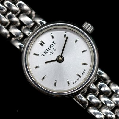 a close up of a wrist watch with a chain around it