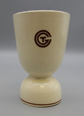 beige and brown ceramic cup with a brown g logo on the bottom