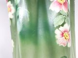 a green vase with pink flowers painted on it