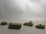 several toy army vehicles are lined up in a row on a white surface