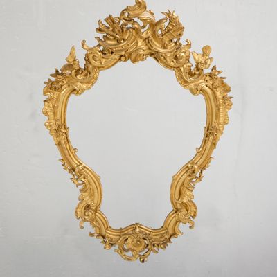 un miroir doré richement décoré accroché au mur d'une pièce