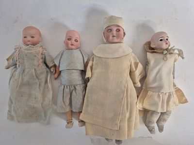 three dolls are lined up against a white wall with a white background