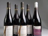 six bottles of wine are lined up in a row on a table