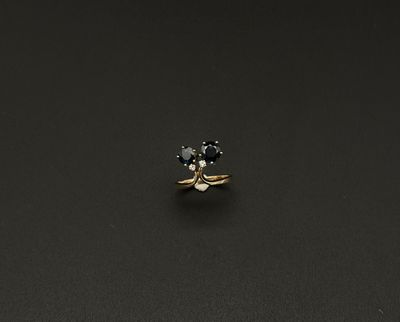 une bague en diamant noir et blanc posée sur une surface noire