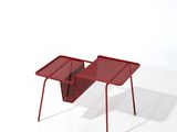 une petite table rouge sur laquelle se trouve un porte-revues
