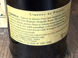 une bouteille de vin posée sur une table à côté d'une pile de livres