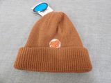 the beanie is brown and has a sticker on it