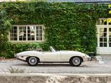 a white car parked in front of a house covered in ivy