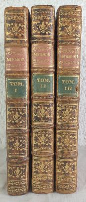 three old books sitting on top of a table next to each other