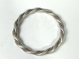 a close up of a silver bracelet on a white surface