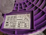 a purple spool sitting on top of a plastic bag