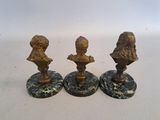 three bronze busturines of children on marble bases
