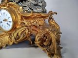 a gold clock sitting on top of a white table