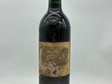 une vieille bouteille de vin posée sur une table blanche