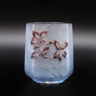 un vase en verre contenant des fleurs, posé sur une surface noire