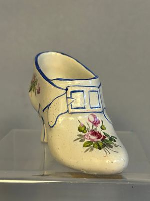 une chaussure blanche avec des bordures bleues et des fleurs dessus