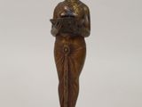 statue en bronze représentant une femme tenant un livre, sur fond blanc