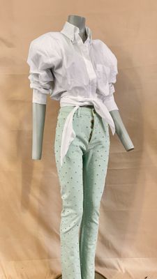 a mannequin wearing a white shirt and green pants