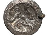 a silver coin with a dragon on it