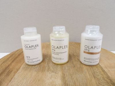 three bottles of soap sitting on a wooden table