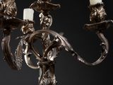 a silver chandelier with three candles on each of it