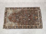 un vieux tapis à motifs floraux posé sur un sol blanc