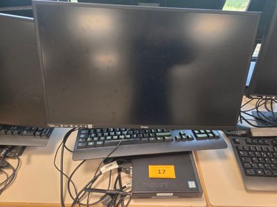 trois écrans d'ordinateur et un clavier posés sur un bureau