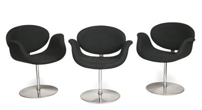 trois chaises noires placées les unes à côté des autres sur une surface blanche