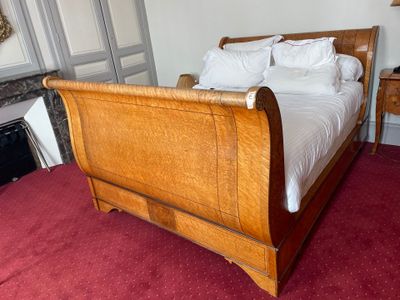 a bed with a wooden sleigh in the middle of a room