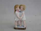 une petite figurine représentant deux enfants debout sur une table
