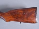 an old wooden rifle is laying on a white surface