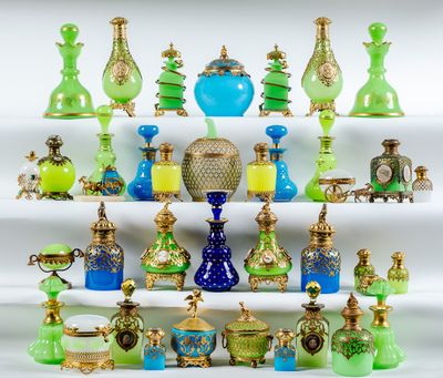 de nombreux vases en verre de différentes couleurs posés sur une étagère blanche