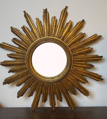 un miroir doré en forme d'étoile posé sur une table en bois