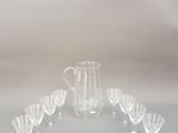 un ensemble composé de six verres et d'un pichet posé sur une table