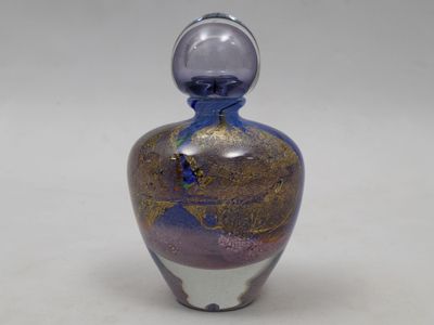 une bouteille en verre ornée d'un motif violet et doré