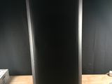 une photo d'une enceinte noire posée sur une table en bois
