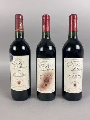 trois bouteilles de vin rouge sont alignées sur une table