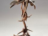 une sculpture représentant un oiseau perché sur une branche d'arbre