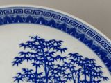 a blue and white plate with a painting on it
